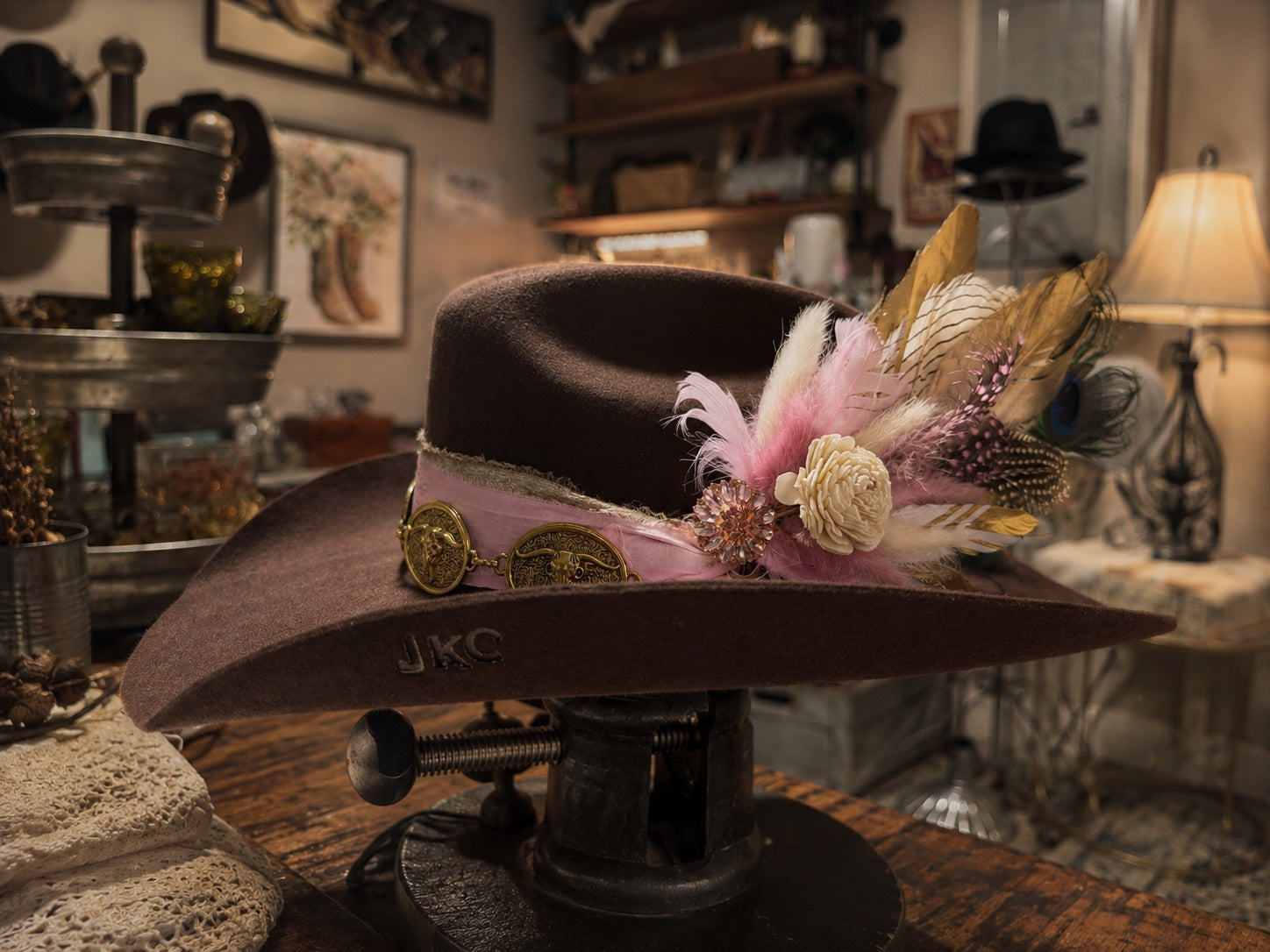 Brown Cattleman crown, traditional cowboy hat, pink raw silk ribbon, bouquet of feathers and dried flowers
metal hat band in gold tone